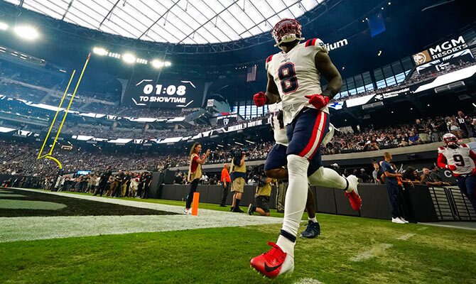 Ja Whaun Bentley de los Patriots salta al campo de juego seguido por sus compañeros