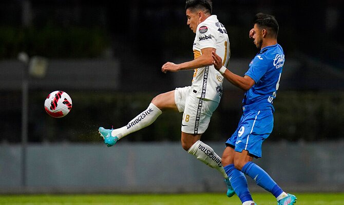 Efrain Velarde de Pumas rechaza el balon ante Angel Romero de Cruz Azul