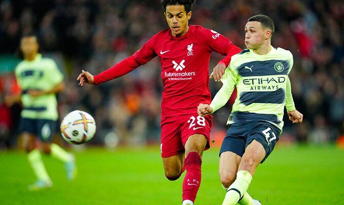 Fabio Carvalho de Liverpool y Phil Foden de Manchester City disputan el balon