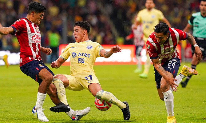 Alejandro Zendejas del America y Jesus Sanchez de las Chivas disputan el balon