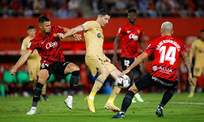 Robert Lewandowski del Barcelona protege el balón ante varios defensores del Mallorca