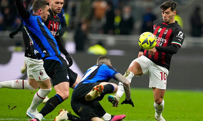 Jugadores de AC Milán e Inter disputan el balón en el derby por Serie A