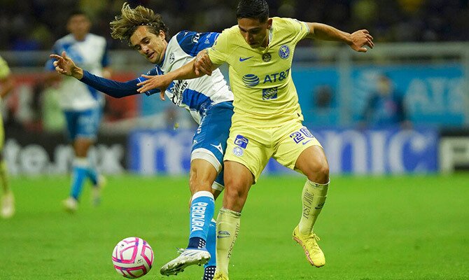Salvador Reyes de America y Gaston Silva de Puebla luchan por el balon