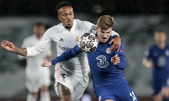 Militao y Werner luchan por controlar el balón. Cuotas y picks para el Chelsea vs Real Madrid.