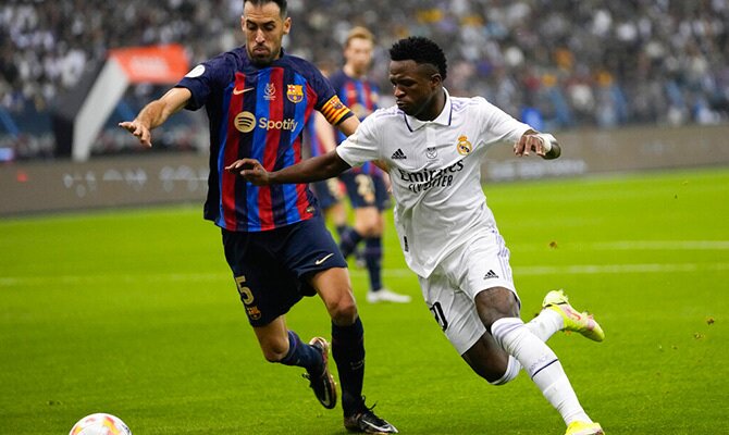Sergio Busquets del Barcelona y Vinicius Jr del Real Madrid buscan el balon